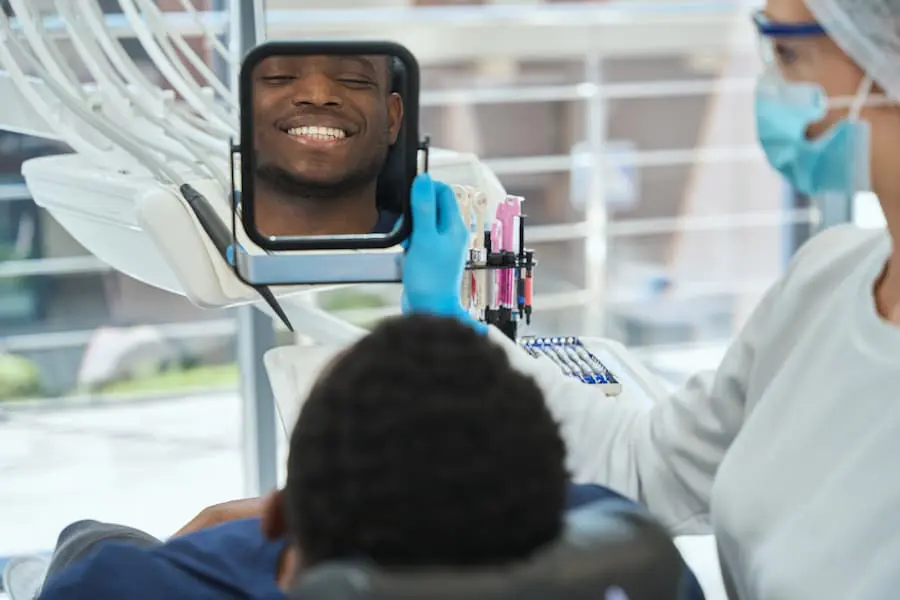 Patient looking at result after dental treatment in clinic